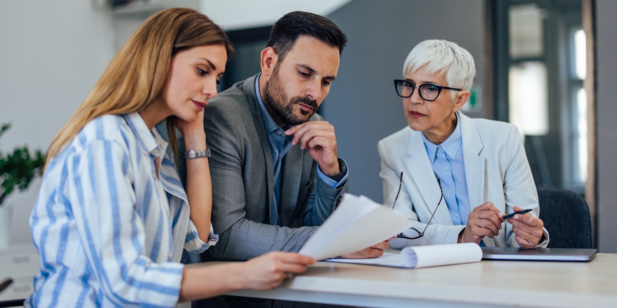 A financial planner reviewing documents with two clients